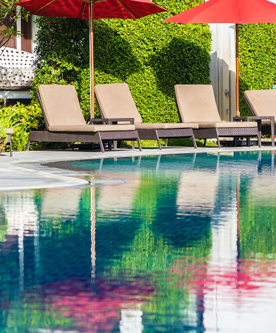 Pool with lounge chairs and red umbrellas